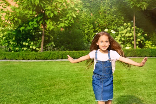 Schattig klein meisje loopt in groen park op de zomerdag — Stockfoto