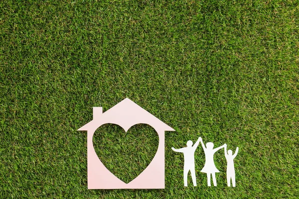 Figuri de hârtie de familie fericită și casă cu inimă pe iarbă verde, lac plat — Fotografie, imagine de stoc