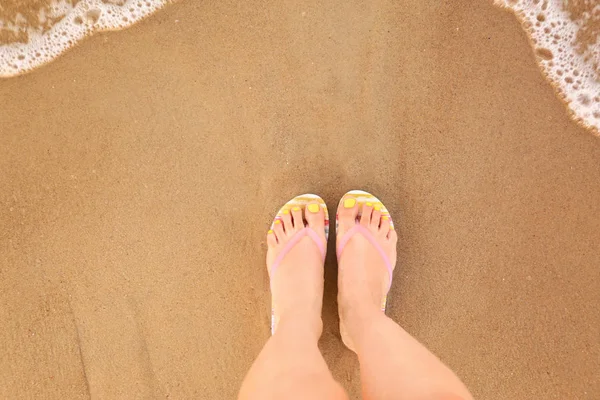 女性的顶景与时尚的拖鞋在海边的沙上,文本的空间。海滩配件 — 图库照片