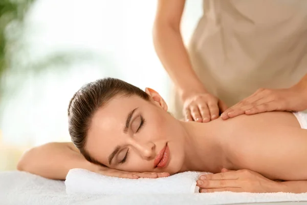 Schöne junge Frau genießt Massage im Wellness-Salon — Stockfoto