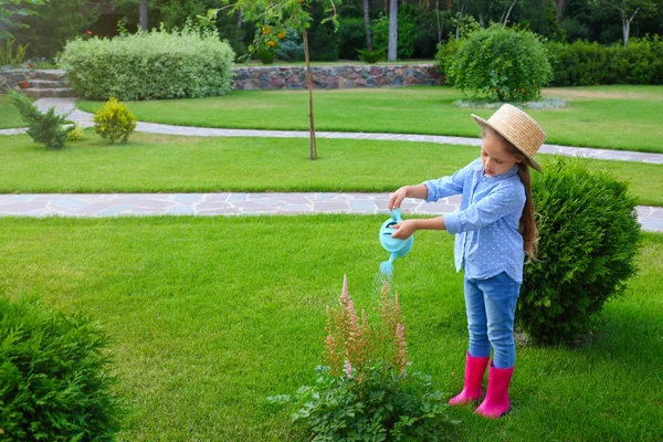 Gadis kecil menyiram bunga di halaman belakang. Berkebun di rumah — Stok Foto