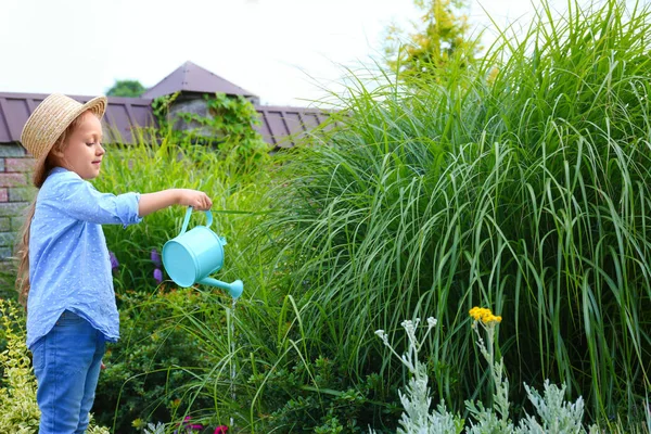 Gadis kecil menyiram tanaman di luar ruangan. Berkebun di rumah — Stok Foto