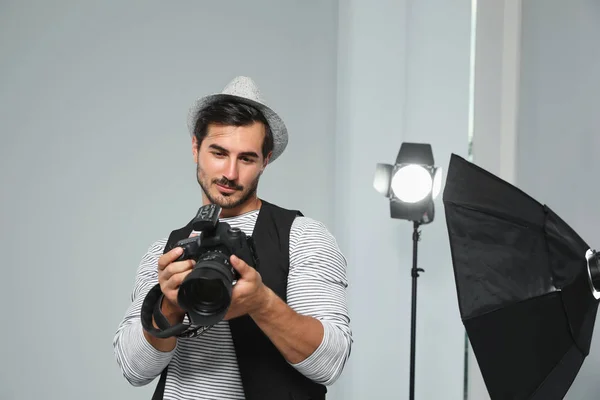 Professioneller Fotograf mit moderner Kamera im Studio — Stockfoto