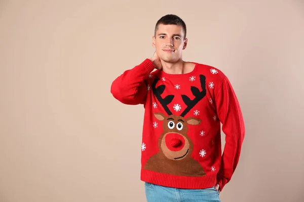 Portrait of happy man in Christmas sweater on beige background — Stock Photo, Image