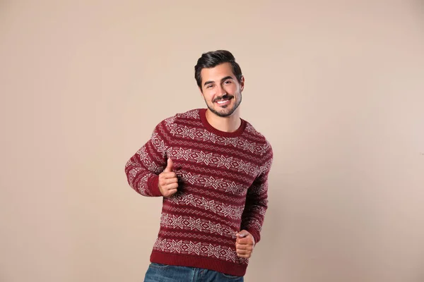 Портрет счастливого человека в рождественском свитере на бежевом фоне — стоковое фото