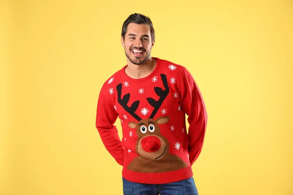 Retrato de un joven feliz en jersey de Navidad sobre fondo amarillo — Foto de Stock