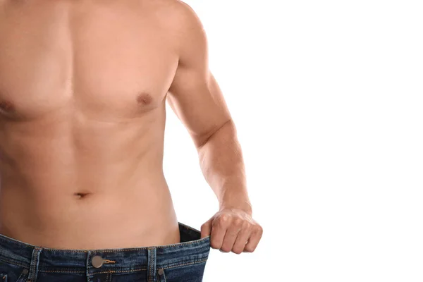 Jonge man met slank lichaam in oude big size jeans op witte achtergrond, close-up bekijken — Stockfoto