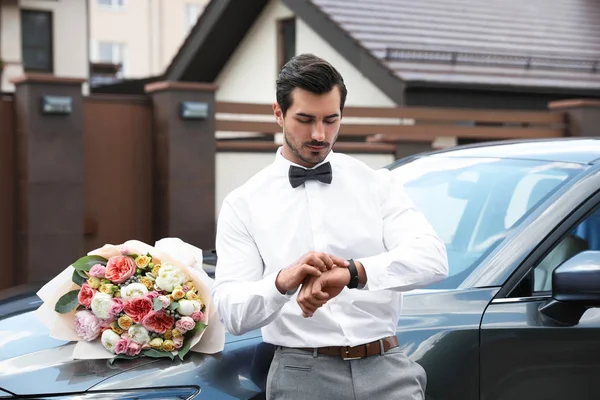 젊은 잘 생긴 남자 와 아름다운 꽃 꽃다발 근처 자동차 옥외 — 스톡 사진