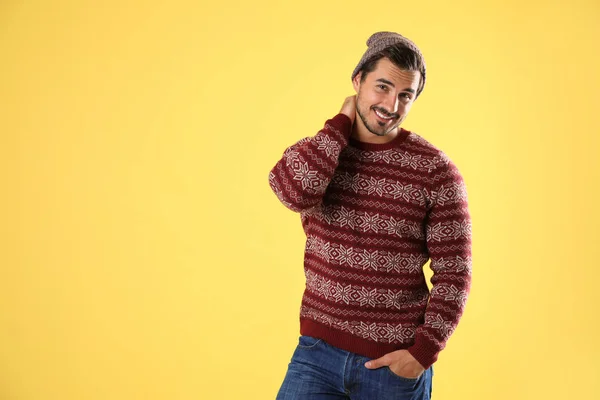 Портрет молодого человека в рождественском свитере и шляпе на желтом фоне. Пространство для текста — стоковое фото
