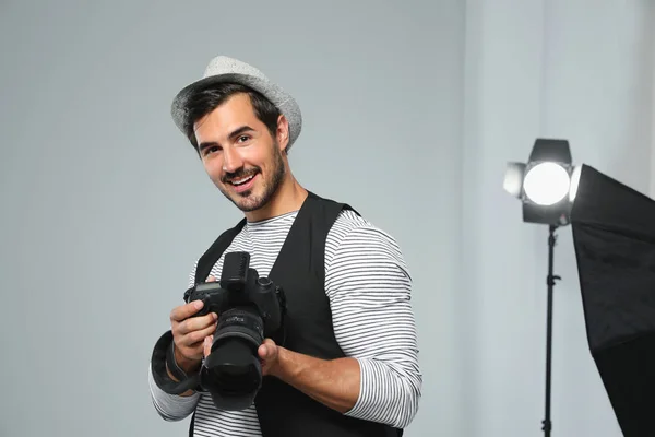 Fotógrafo profissional com câmera moderna em estúdio — Fotografia de Stock