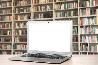 Kütüphanede masada boş ekran ile modern dizüstü bilgisayar. Tasarım alanı 