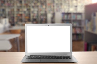 Kütüphanede masada boş ekran ile modern dizüstü bilgisayar. Tasarım alanı 