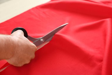 Profesyonel terzi kesme kırmızı kumaş içinde makas ile atölye, çekim