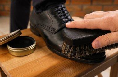 Adam ahşap tabure üzerinde müşteri Ayakkabı parlayan kapalı, kapatmak