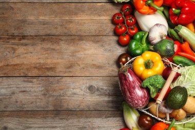 Ahşap masa üzerinde taze sebze ve metal sepet, düz yatıyordu. Metin için alan