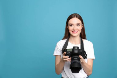 Açık mavi arka plan da modern kamera ile profesyonel fotoğrafçı