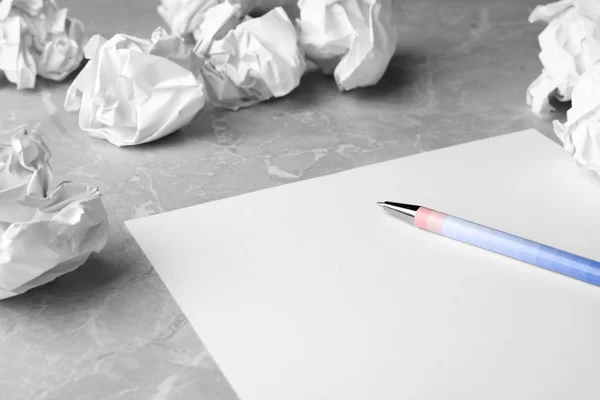 Folha em branco, caneta e bolas de papel amassadas na mesa cinzenta. Espaço para texto — Fotografia de Stock