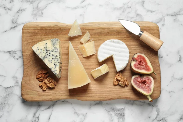 Diferentes deliciosos queijos servidos na mesa de mármore, vista superior — Fotografia de Stock