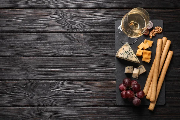 Different types of delicious cheese served on black wooden table, top view. Space for text — Stock Photo, Image