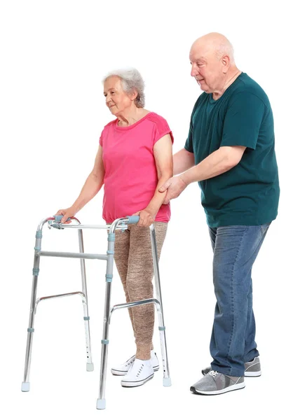 Ηλικιωμένος άνθρωπος βοηθώντας τη γυναίκα του με το πλαίσιο περπάτημα σε λευκό φόντο — Φωτογραφία Αρχείου