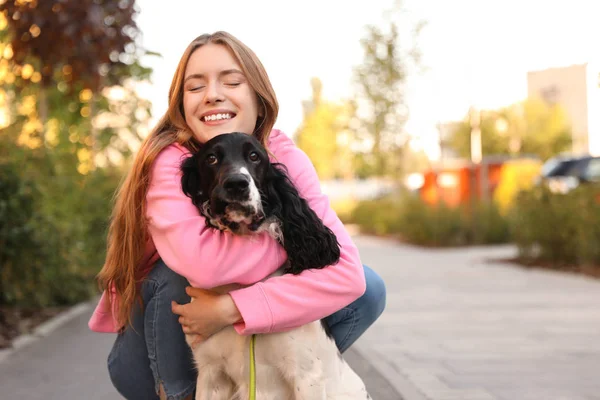 Young woman hugging her English Springer Spaniel dog outdoors. Space for text — Stock Photo, Image