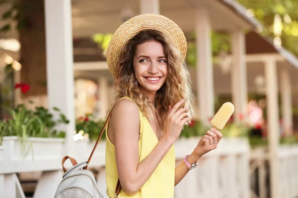 Счастливая молодая женщина с вкусным мороженым на открытом воздухе — стоковое фото