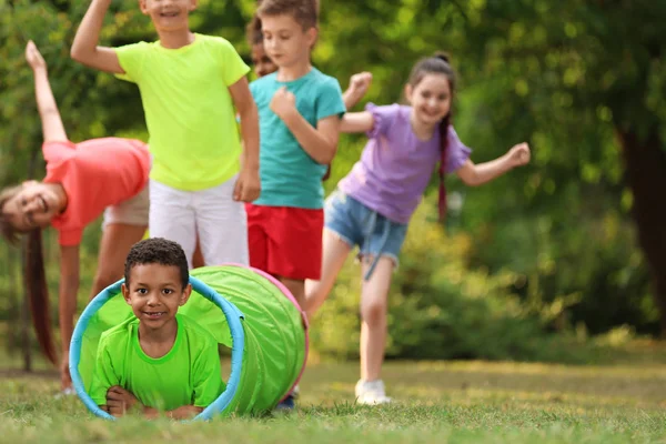 Niedliches kleines afrikanisch-amerikanisches Kind, das mit Freunden im Park spielt, Platz für Text — Stockfoto