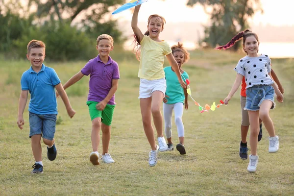 Niedliche kleine Kinder spielen mit Drachen im Freien — Stockfoto