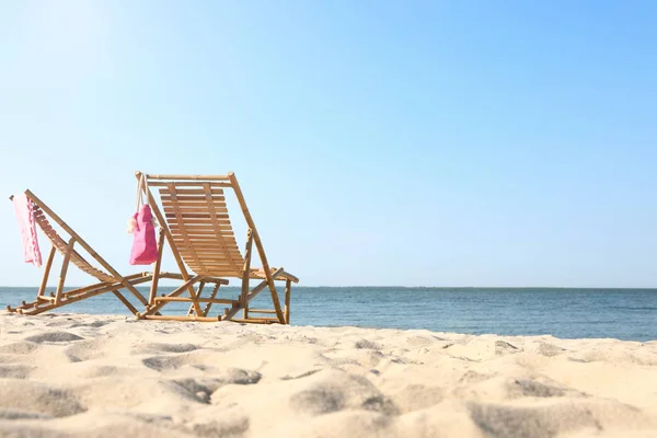 砂浜の空の木製サンベッドとビーチアクセサリー — ストック写真