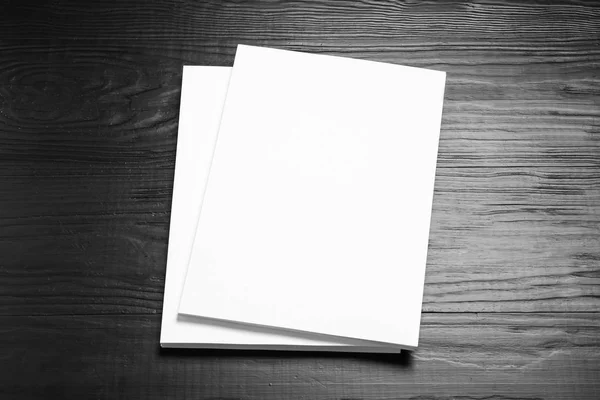Пачка чистых листов бумаги для брошюры на черном деревянном фоне. Mock up — стоковое фото