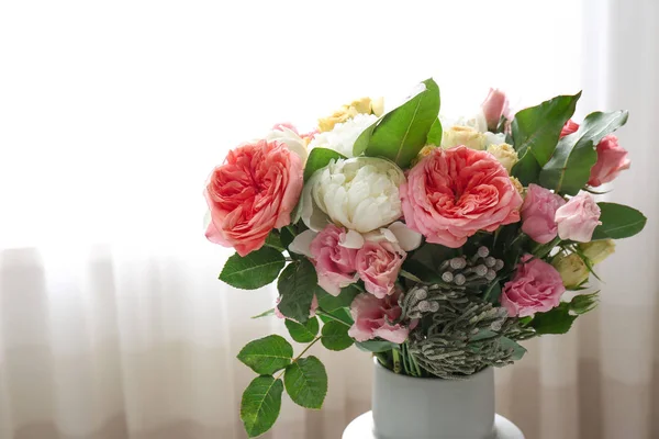 Vaso com lindo buquê de flores na frente da janela — Fotografia de Stock