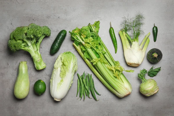 Composición plana de las diferentes verduras verdes en la mesa gris — Foto de Stock