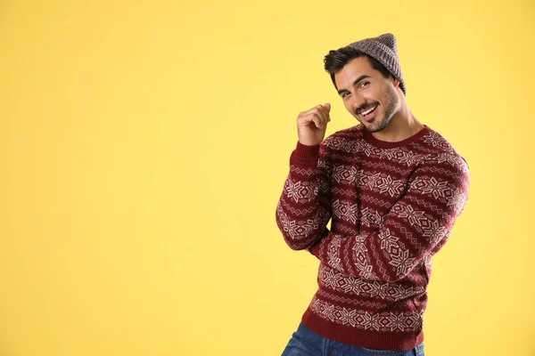 Ritratto di giovane in maglione natalizio e cappello su sfondo giallo. Spazio per testo — Foto Stock