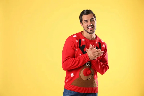 Retrato de jovem feliz em camisola de Natal no fundo amarelo — Fotografia de Stock