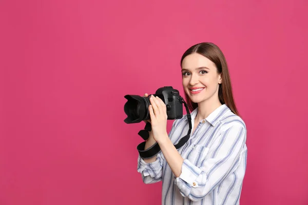 Fotógrafo profissional com câmera moderna em fundo rosa — Fotografia de Stock