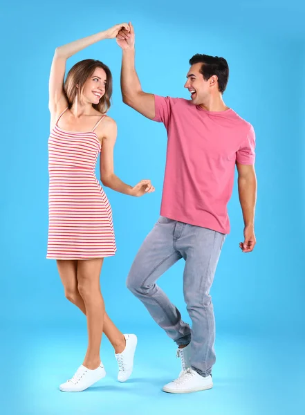 Hermosa pareja joven bailando sobre fondo azul — Foto de Stock