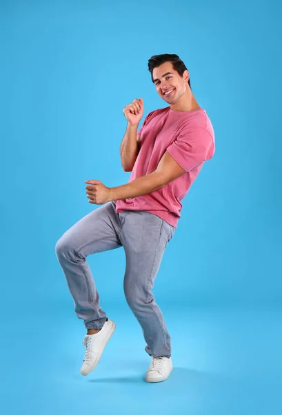 Красивый молодой человек танцует на синем фоне — стоковое фото