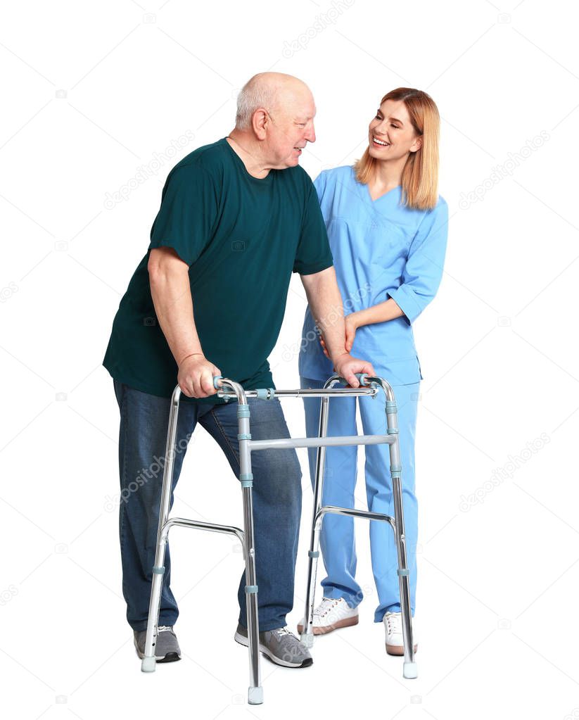 Caretaker helping elderly man with walking frame on white background