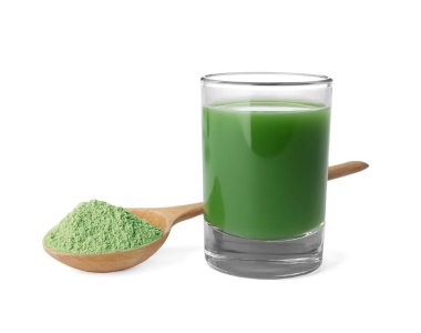 Bardak taze buğday çimen suyu ve toz beyaz zemin üzerine kaşıkla