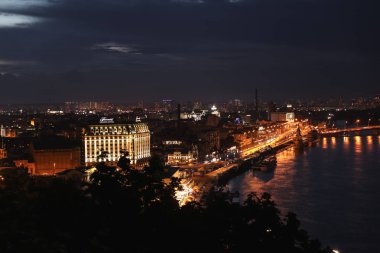 Kiev, Ukrayna - 21 Mayıs 2019: Işıklı Fairmont Grand Hotel ve nehir yakınındaki diğer binalar ile gece şehrinin güzel görünümü