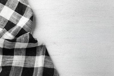 Beyaz ahşap masa üzerinde damalı mutfak havlusu, üst görünümü. Metin için alan