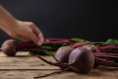 Siyah arka plan, çekim karşı ahşap masada yaprakları ile taze pancar. Metin alanı