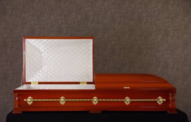 Açık ahşap cenaze tabut gri duvarda standında