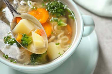 Masada tam yemek üzerinde taze ev yapımı sebze çorbası Kaşık, closeup