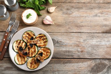 Izgara kabak dilimleri ahşap masa üzerinde sos ile servis, düz yatıyordu. Metin için alan