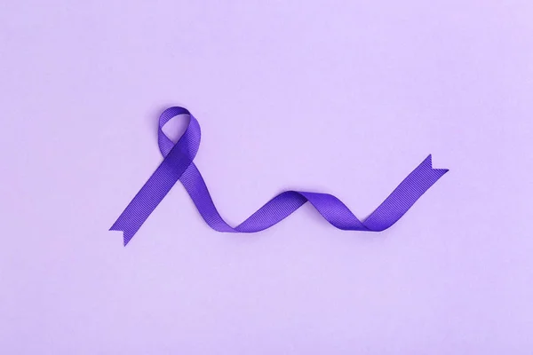 Purple awareness ribbon on lilac background, top view