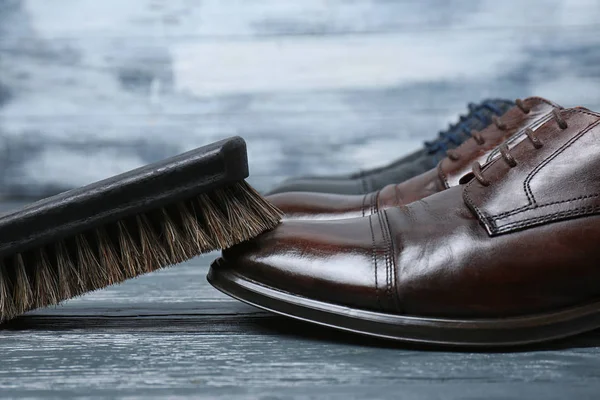 Мужская кожаная обувь и чистящая щетка на сером столе — стоковое фото