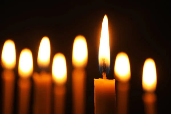 Brandende kaarsen op donkere achtergrond, ruimte voor tekst. Symbool van verdriet — Stockfoto