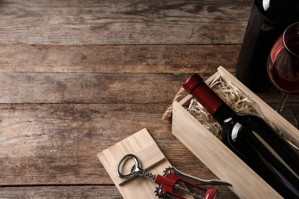 Komposition med trälåda och flaskor vin på bordet, utrymme för text — Stockfoto