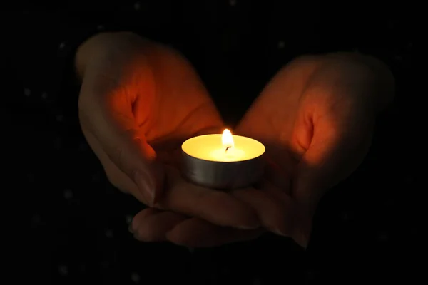 Mulher segurando vela acesa na escuridão, close-up — Fotografia de Stock